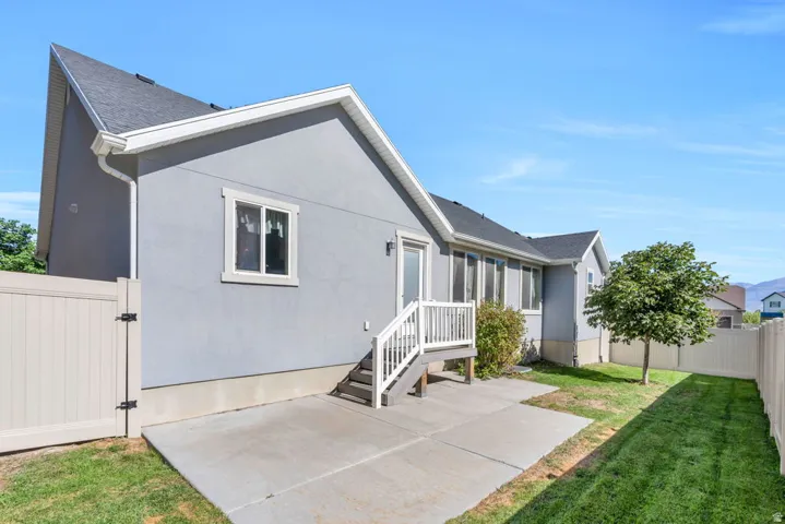 Backyard, Exterior siding, asphalt shingle roofing, concrete patio, white railing, and a fenced yard
