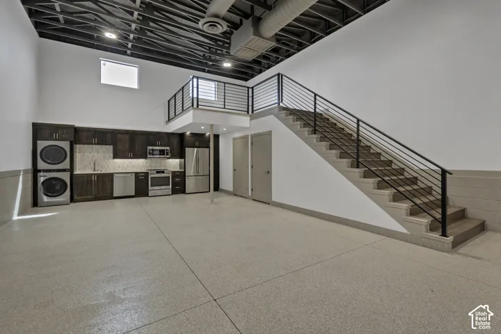 Full-sized kitchen with dark wood-finish cabinetry, stainless steel appliances, and a tiled backsplash