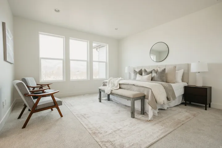Recessed lighting, large windows, wall-to-wall carpeting, and a neutral color palette