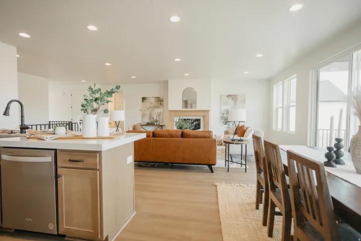 Kitchen island with a stainless steel dishwasher, wood-finish flooring, recessed lighting, expansive windows, and a built-in fireplace