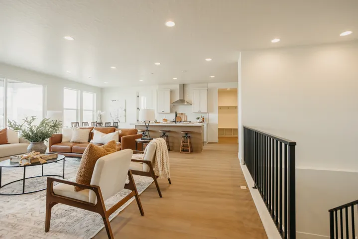 Open-concept living area with wood-finish flooring, recessed lighting, and expansive windows