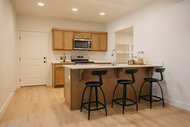 Kitchen featuring wood-finish flooring, recessed lighting, and a kitchen island with seating space
