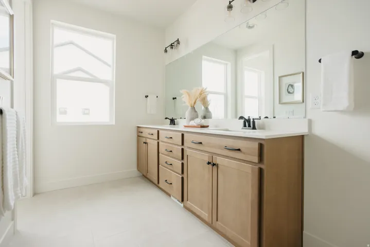 Dual vanity with wood-finish cabinetry and matte black hardware