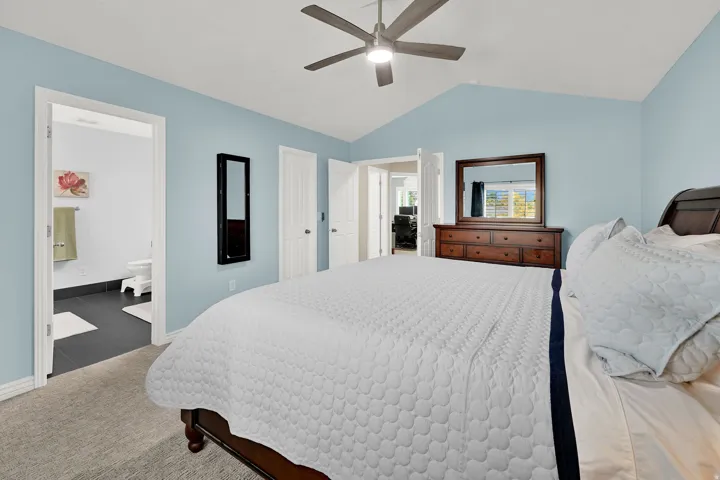 Vaulted ceiling with a ceiling fan, recessed lighting, and an attached bathroom
