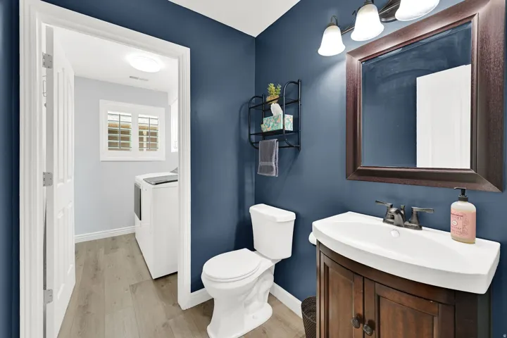 Vanity with a wood-finish base, integrated basin, and dark bronze faucet