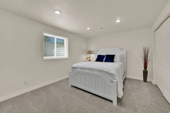 Recessed lighting illuminates neutral walls and gray carpeting