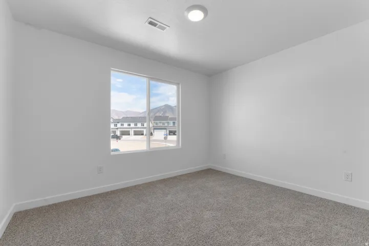 Neutral color palette with textured carpeting and recessed ceiling lighting