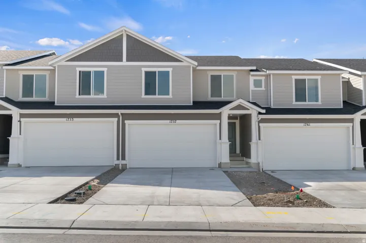 Contemporary multi-unit residence with light gray horizontal siding and dark gray shingle accents