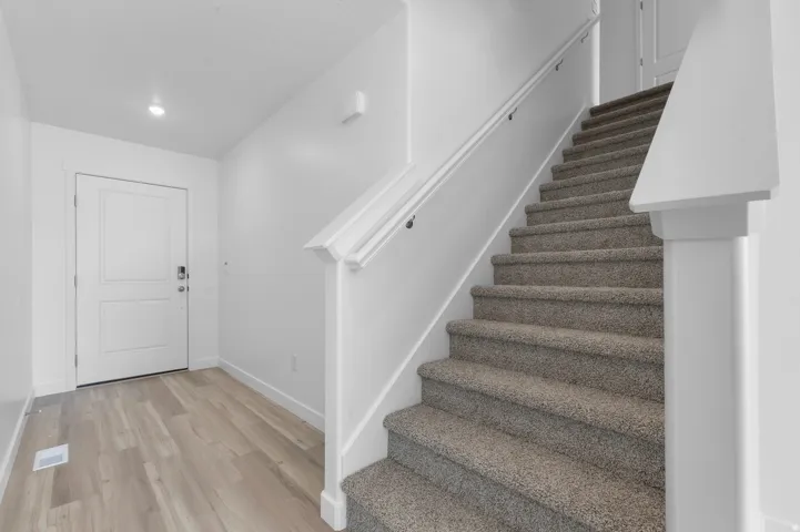 Entryway featuring wood-finish flooring, a two-panel door with a smart lock, and recessed lighting