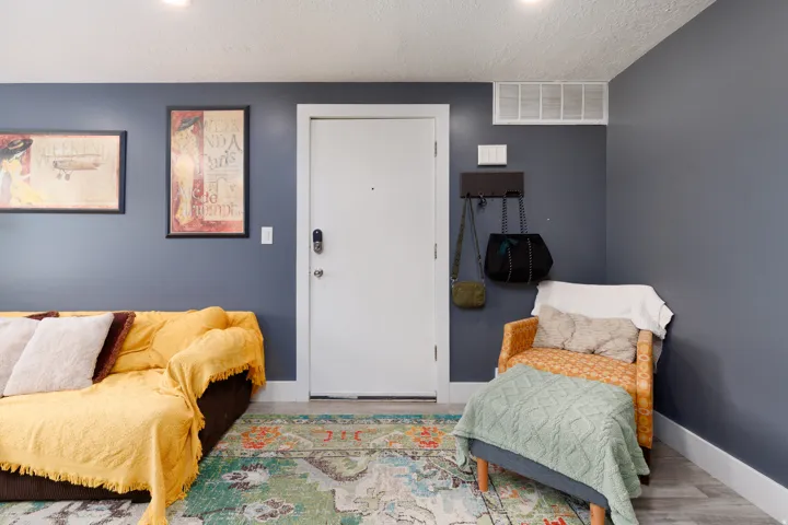 White entry door with smart lock hardware, recessed ceiling lighting, and wood-finish flooring