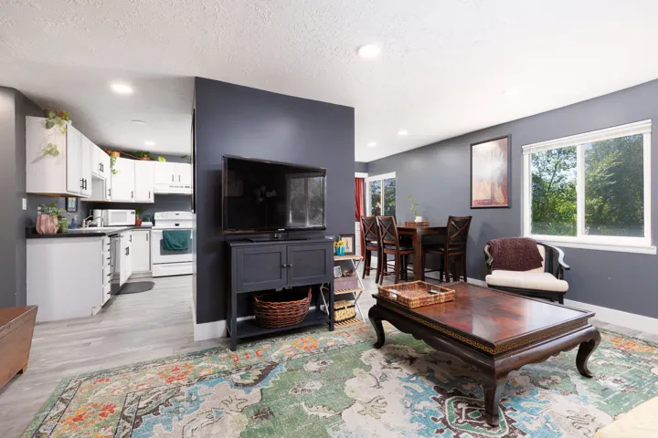 Recessed lighting illuminates the living space with wood-finish flooring