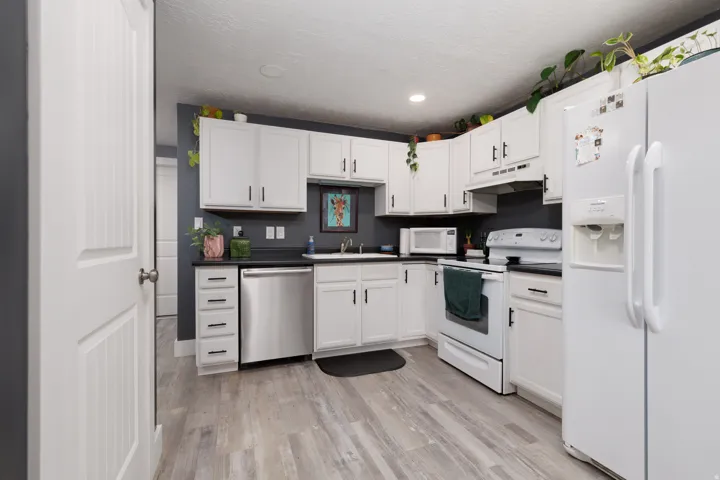 White cabinetry with black hardware, complementing black countertops