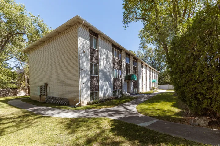 Light-colored brick exterior with dark accent panels and multiple windows