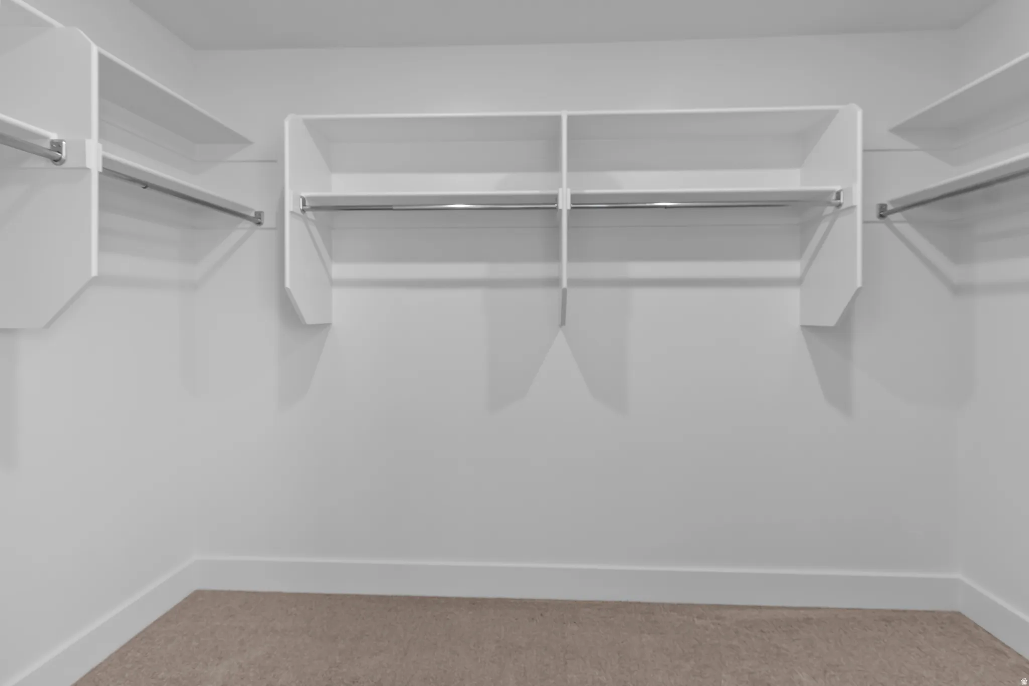 Built-in white shelving and chrome hanging rods