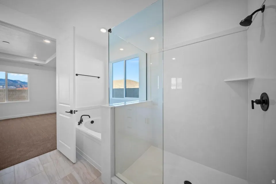 Contemporary bathroom featuring a spacious glass-enclosed shower, built-in soaking tub with matte black fixtures, and tile flooring