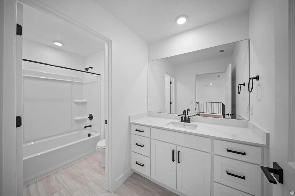 White vanity with ample storage, integrated sink, and black fixtures
