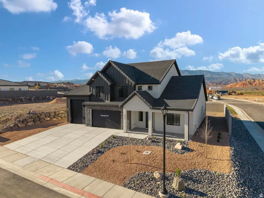 Contemporary exterior with a covered entry, two-car garage, and a low-maintenance landscape