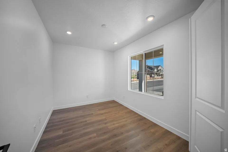 Wood-finish flooring, recessed lighting, and a paneled door
