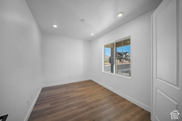 Wood-finish flooring, recessed lighting, and a paneled door