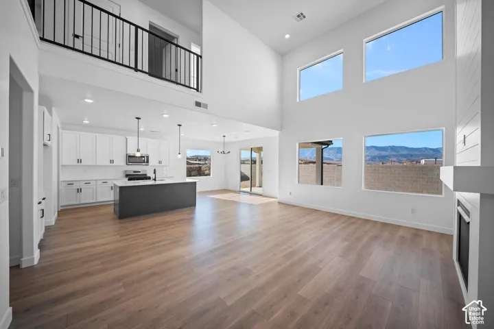 Open-concept living space with wood-finish flooring and high ceilings