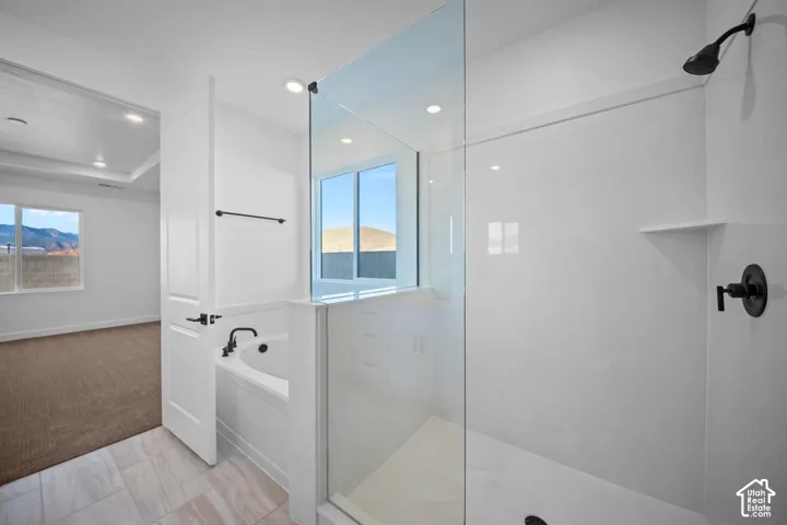 Contemporary bathroom featuring a spacious glass-enclosed shower, built-in soaking tub with matte black fixtures, and tile flooring