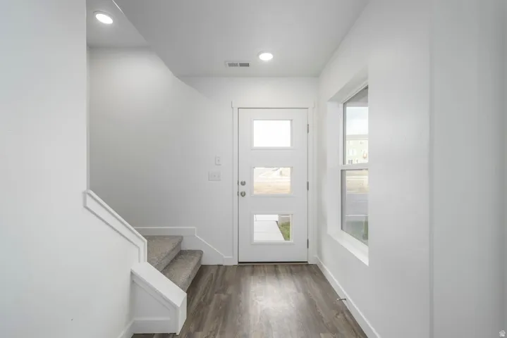 Bright entryway featuring recessed ceiling lighting, wood-finish flooring, and white painted walls