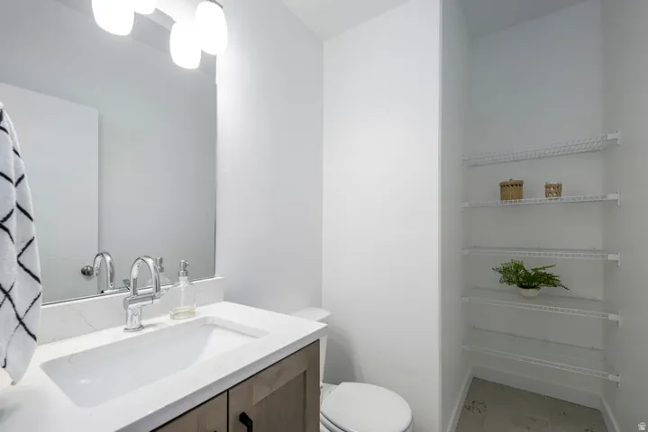 Vanity with stone-finish countertop, undermount sink, and chrome faucet