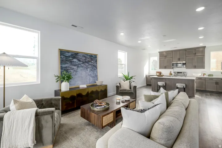 Open-concept living space with recessed lighting, wood-finish flooring, and multiple windows