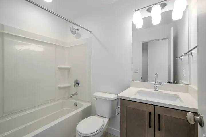Modern bathroom featuring a wood-finish vanity with dual storage cabinets, white quartz countertop, and chrome faucet
