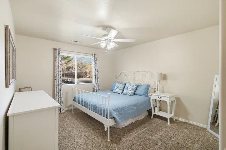 Carpeted room with a ceiling fan, a window with blinds, and neutral wall tones