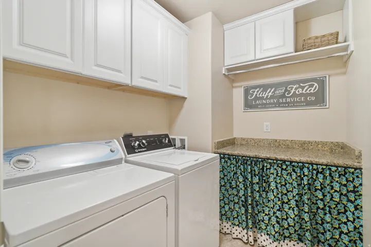 White shaker cabinetry, upper shelving, and a speckled countertop