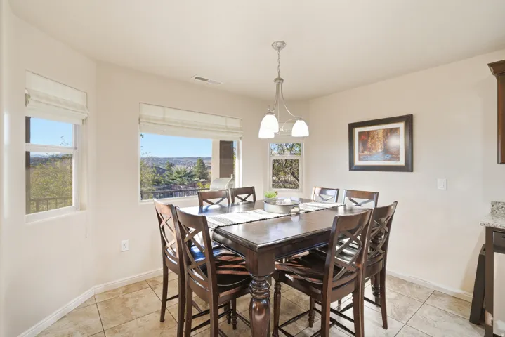 Tile flooring, suspended light fixture, multiple windows, and a built-in cabinet with a stone countertop