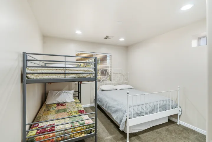 Recessed lighting throughout, wall-to-wall carpeting, and a window with horizontal blinds