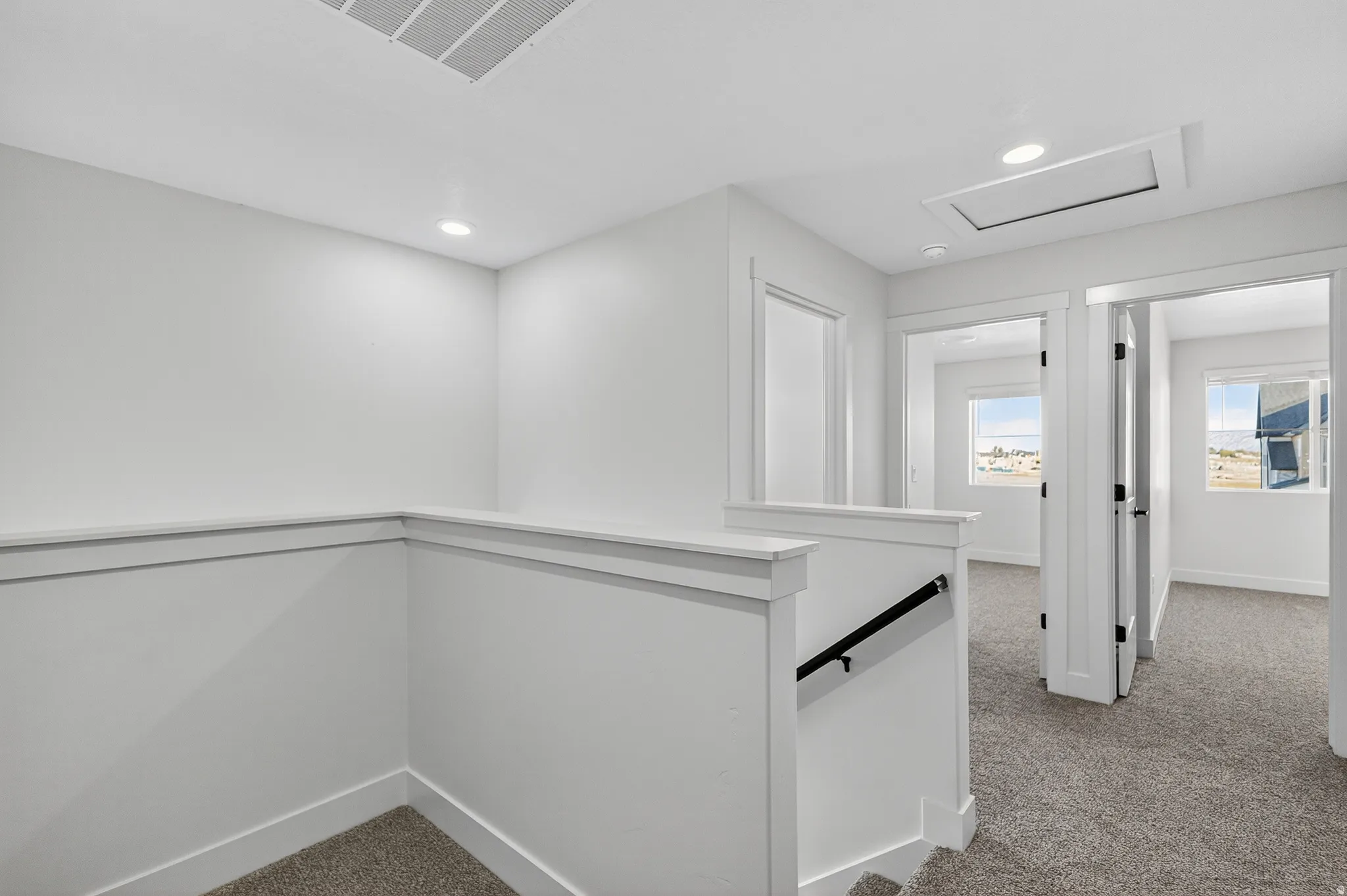 Carpeted hallway with white walls and trim, recessed lighting, and white paneled doors