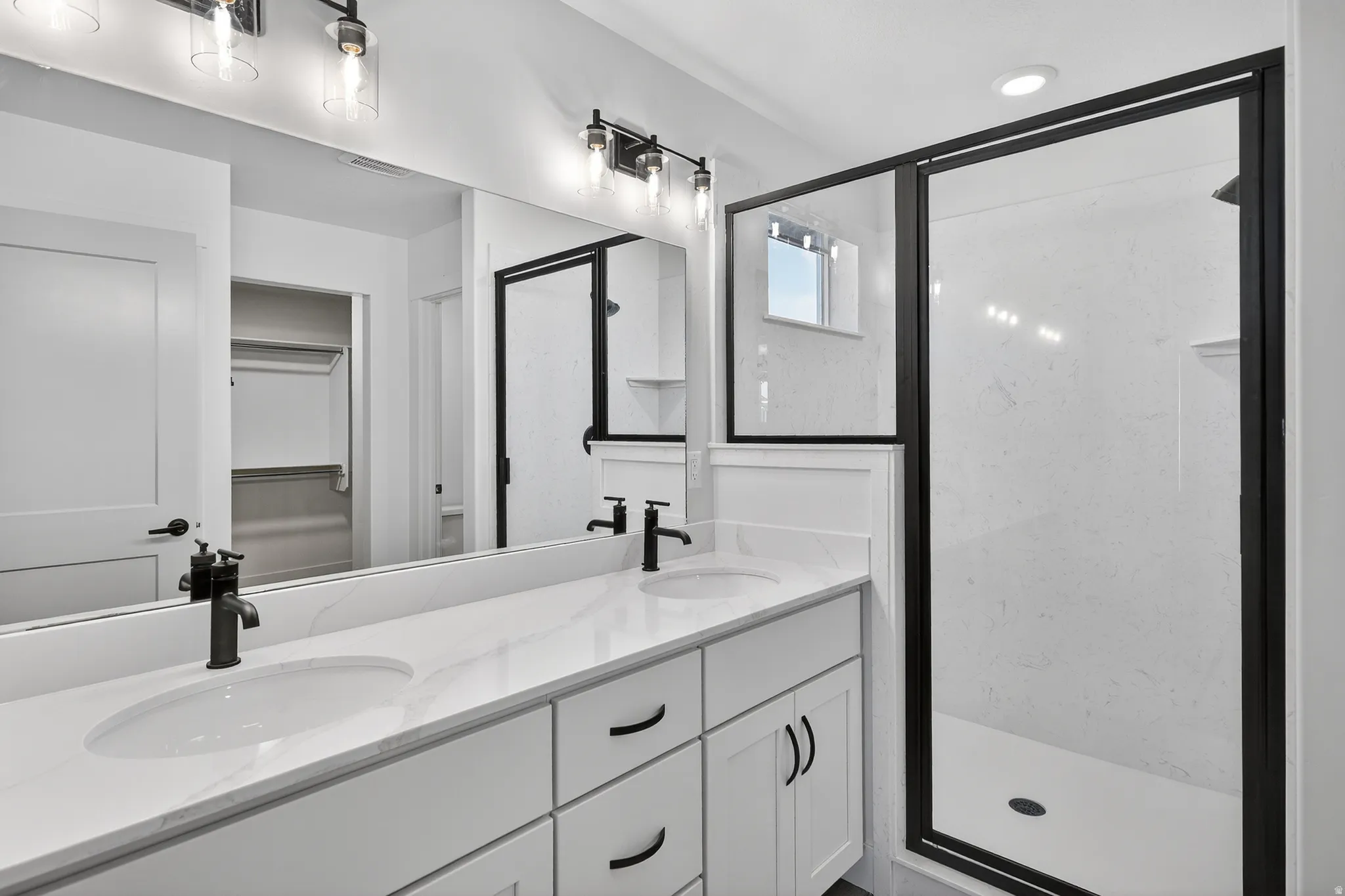 Dual vanity with undermount sinks, stone-finish countertop, and matte black hardware