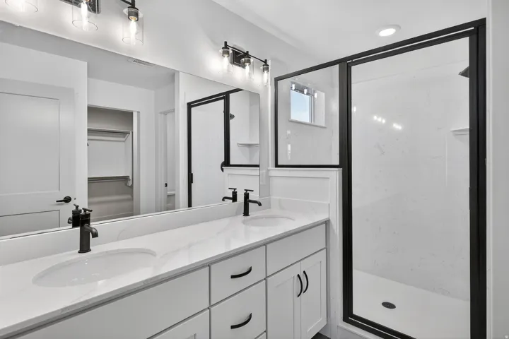 Dual vanity with undermount sinks, stone-finish countertop, and matte black hardware