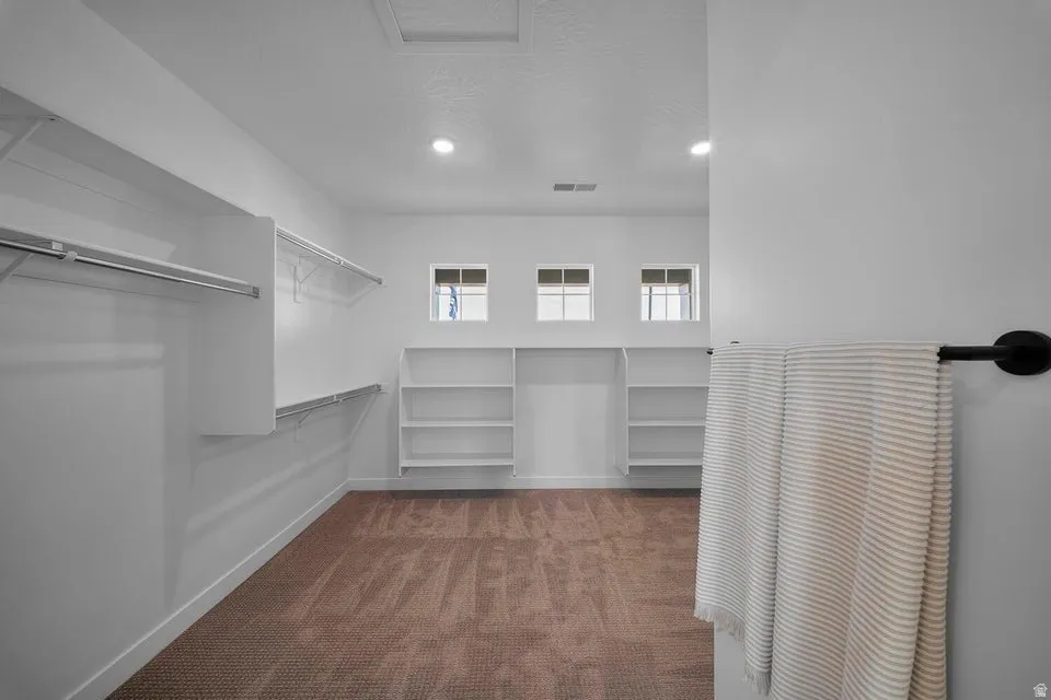 Built-in shelving, hanging rods, recessed lighting, and three transom windows