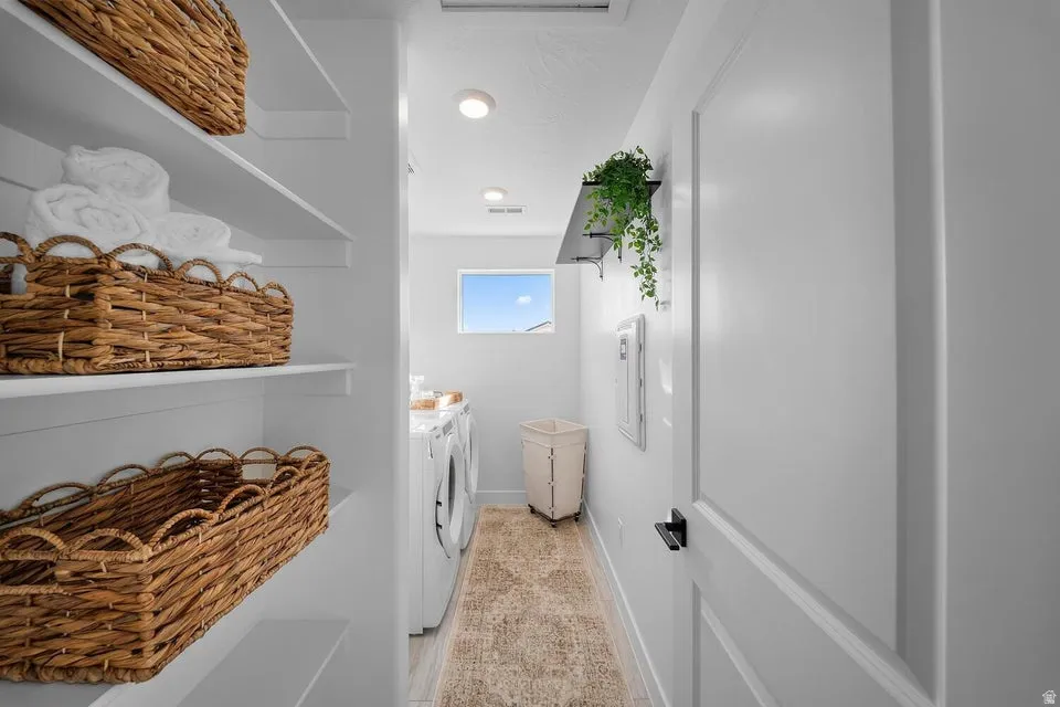 Laundry area featuring white built-in shelving, white walls, and recessed lighting