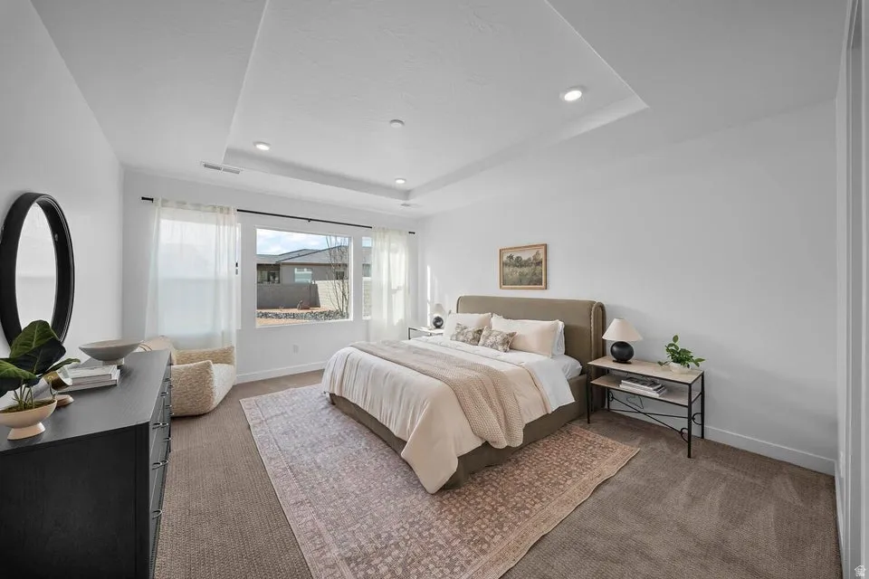 Spacious room with large windows, recessed lighting, a tray ceiling, and neutral carpeting