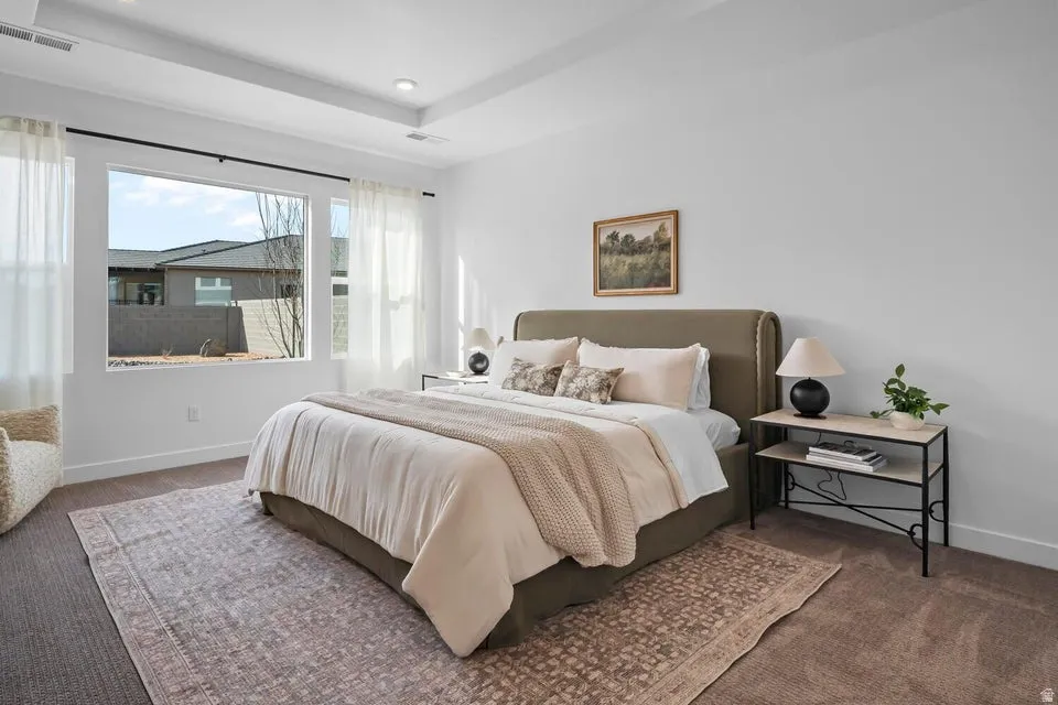 Recessed lighting with a tray ceiling, large picture windows, and neutral wall tones