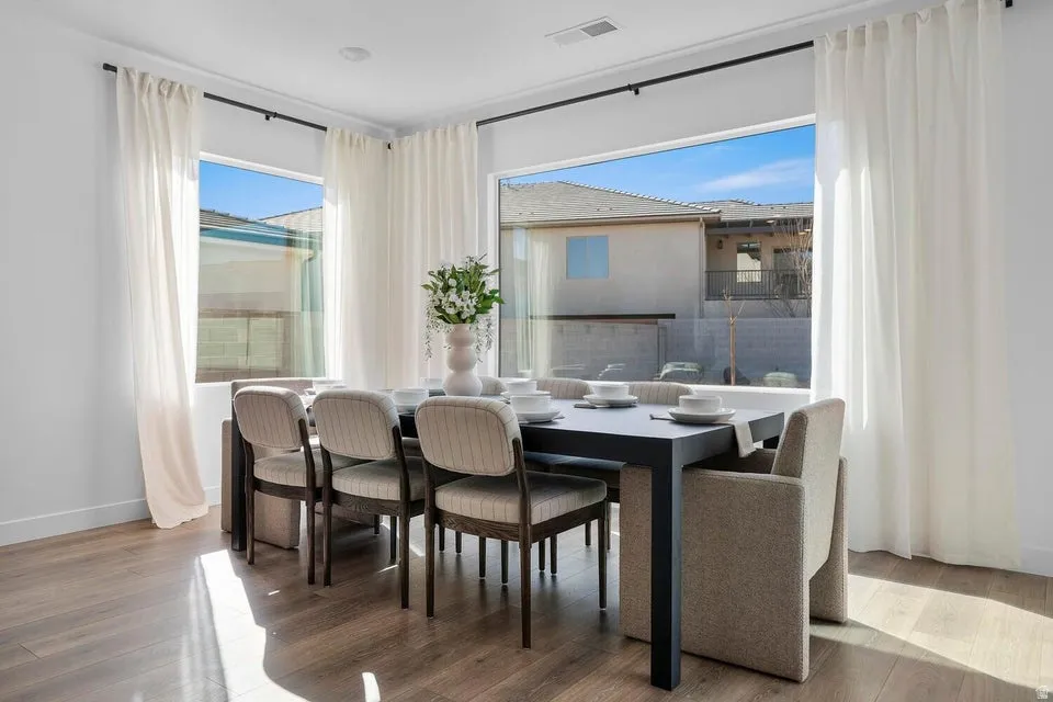 Expansive window framing the exterior, wood-finish flooring, and white painted walls