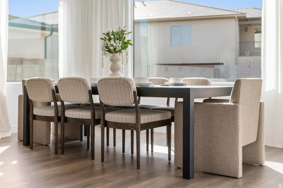 Expansive glass paneling, full-height sheer drapery, and wood-finish flooring