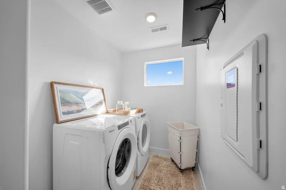 Dedicated laundry space featuring a window, overhead shelving, and recessed lighting