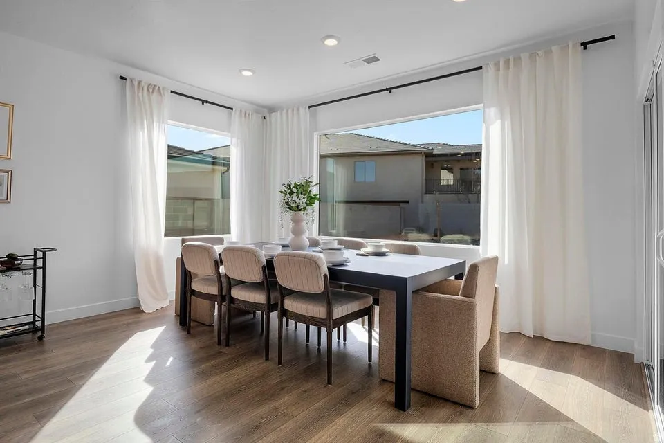 Spacious dining area featuring wood-finish flooring, recessed lighting, expansive windows, and white walls