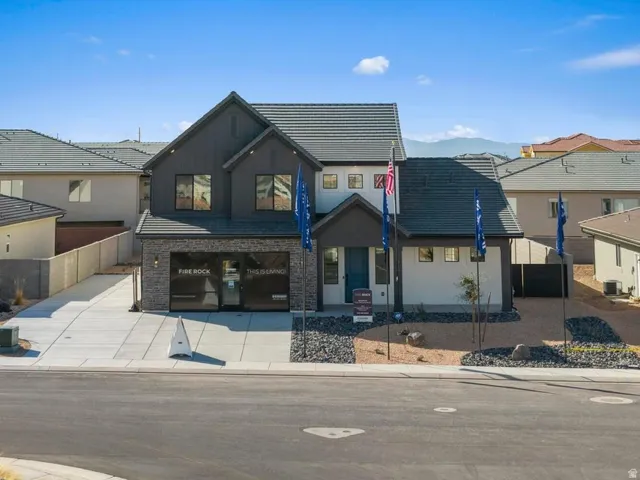 Contemporary exterior with dark siding, stone accents, and a light-colored stucco finish