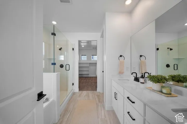 Dual vanity with undermount sinks, stone countertops, and matte black fixtures