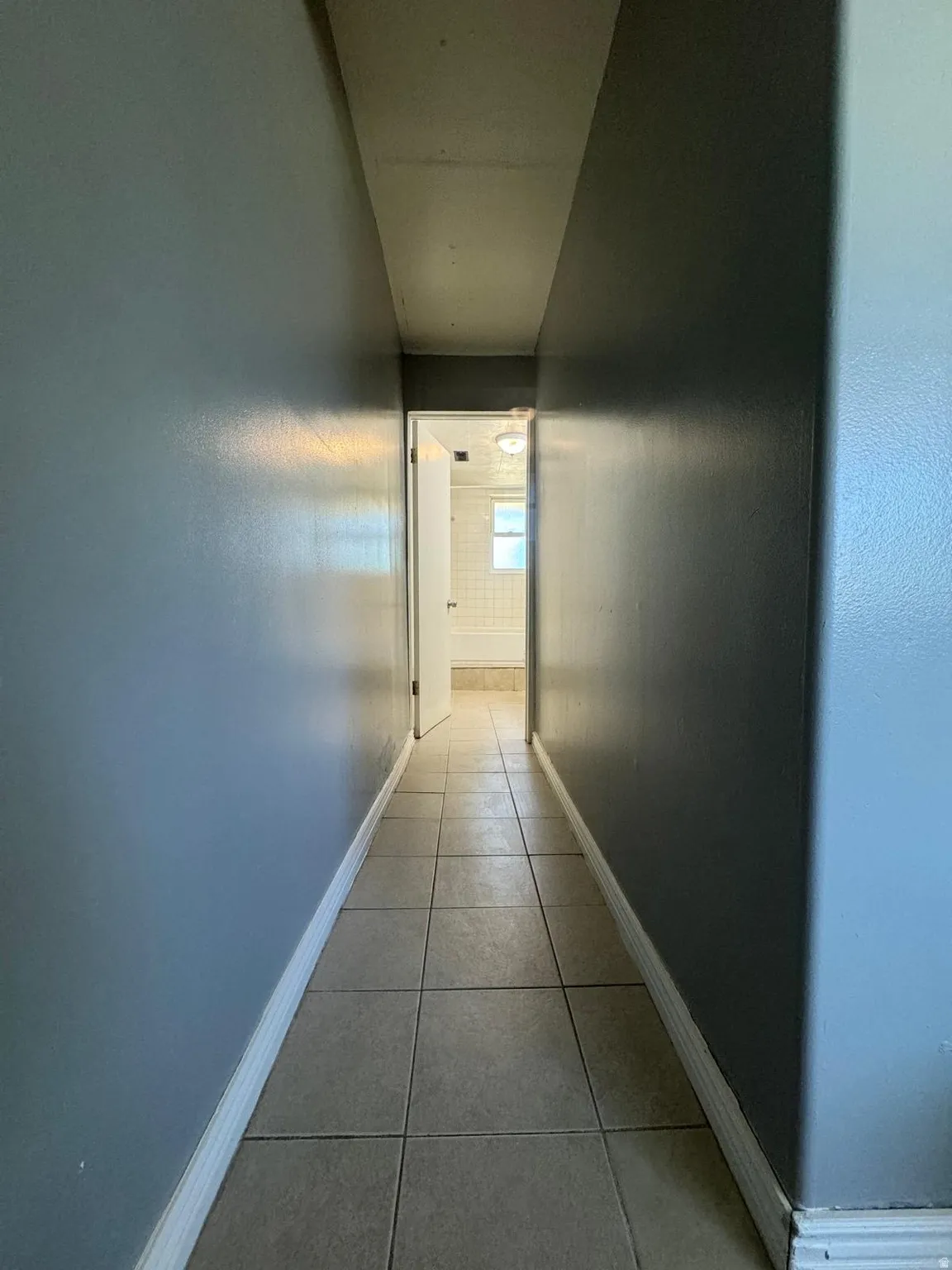 Hallway featuring tile flooring and painted walls