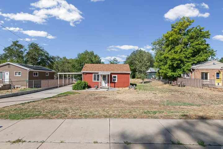 Spacious lot featuring mature shade trees, open grounds ideal for customization, and multiple outbuildings