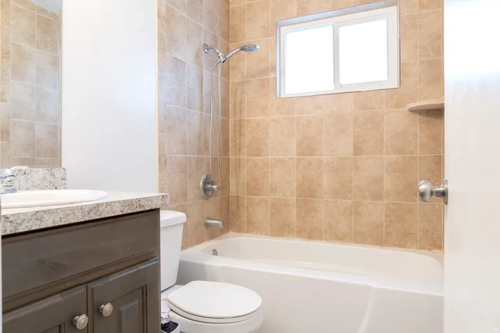 Integrated bathtub with tiled surround.