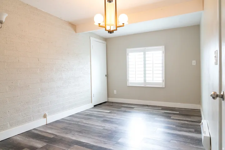 Textured brick accent wall, contemporary chandelier, pantry or storage closet.